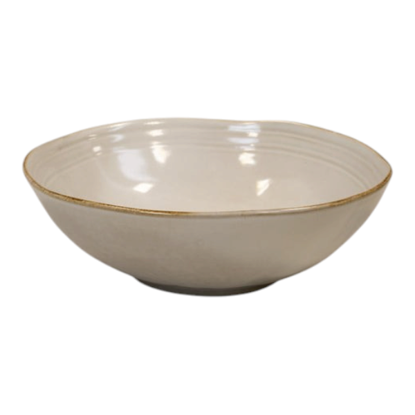 Four Candle Satchville stoneware salad bowl in cream with a rustic rim, set on a white wooden surface.